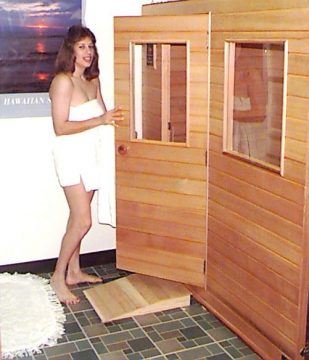 woman wrapped in a towel enters a sauna room